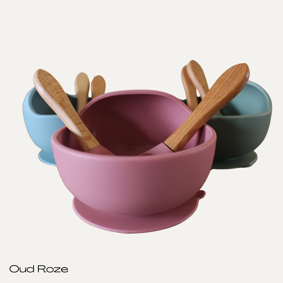 Een bakje met zuignap.
Een lepel en vorkje. Beide hebben een combinatie van siliconen (zacht voor het mondje) en hout (voor een stevige grip).