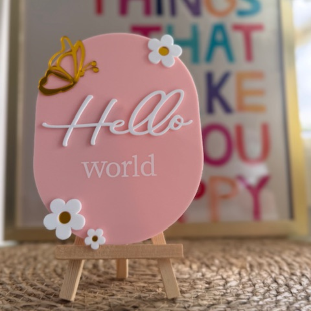 Roze aankondigingsbordje hello world. Kraamcadeau met houten standaard