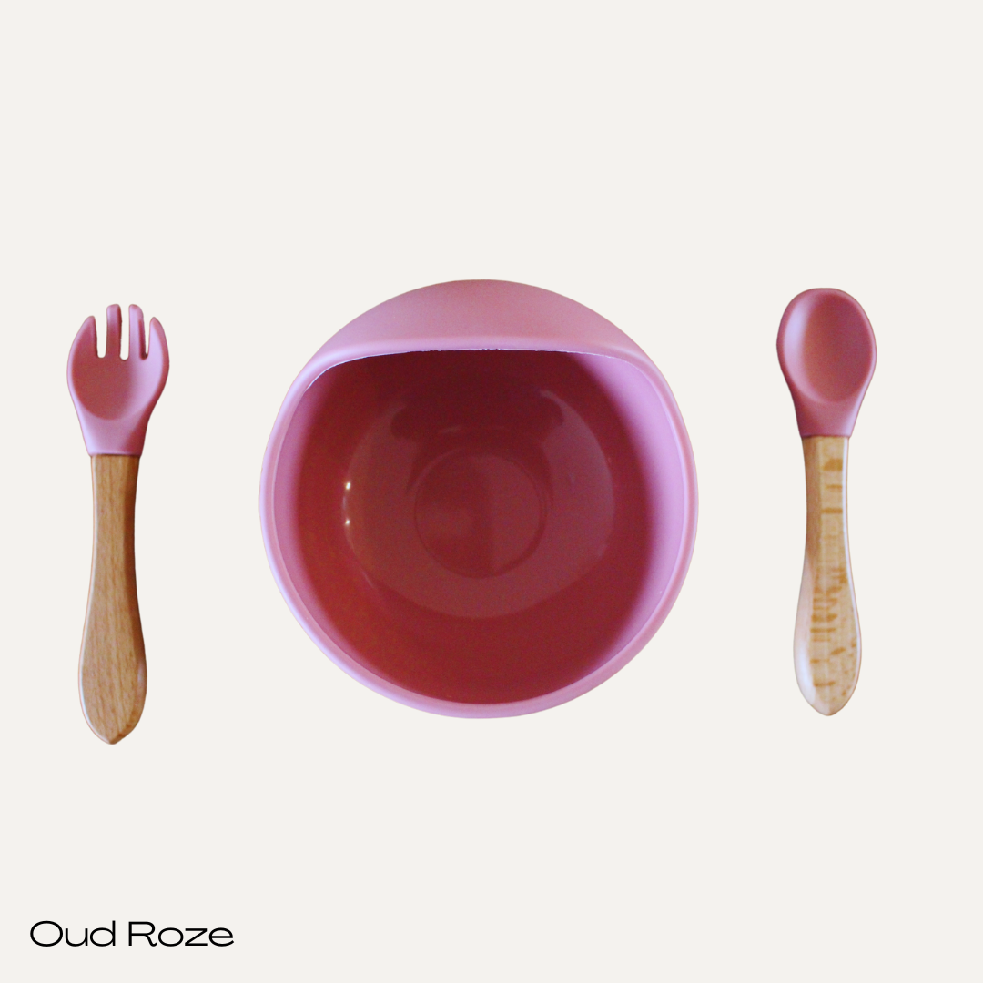 Een bakje met zuignap.
Een lepel en vorkje. Beide hebben een combinatie van siliconen (zacht voor het mondje) en hout (voor een stevige grip).